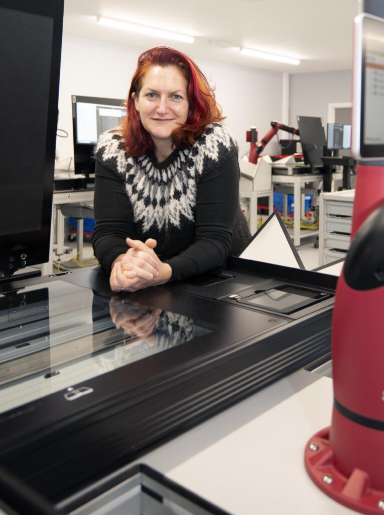 A woman in a photographic robotics room
