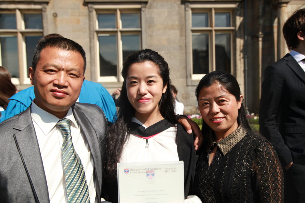 Student with parents at university graduation