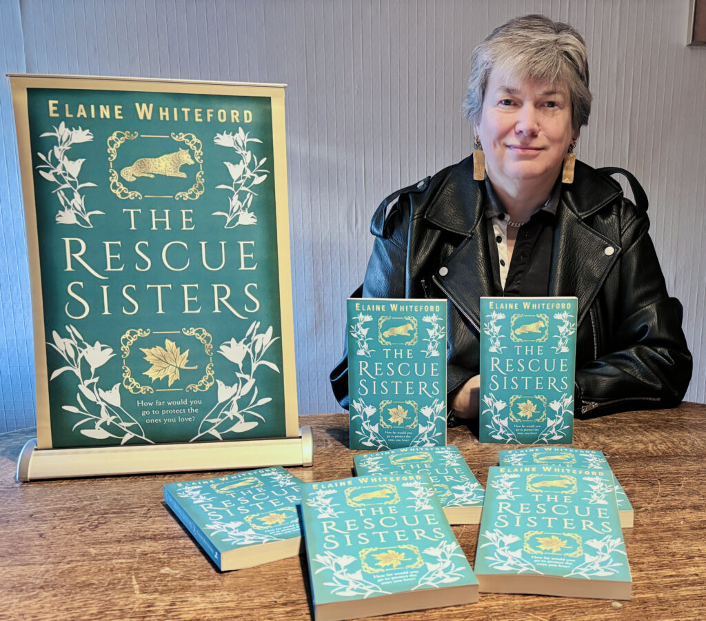 A woman sitting at a table covered in books