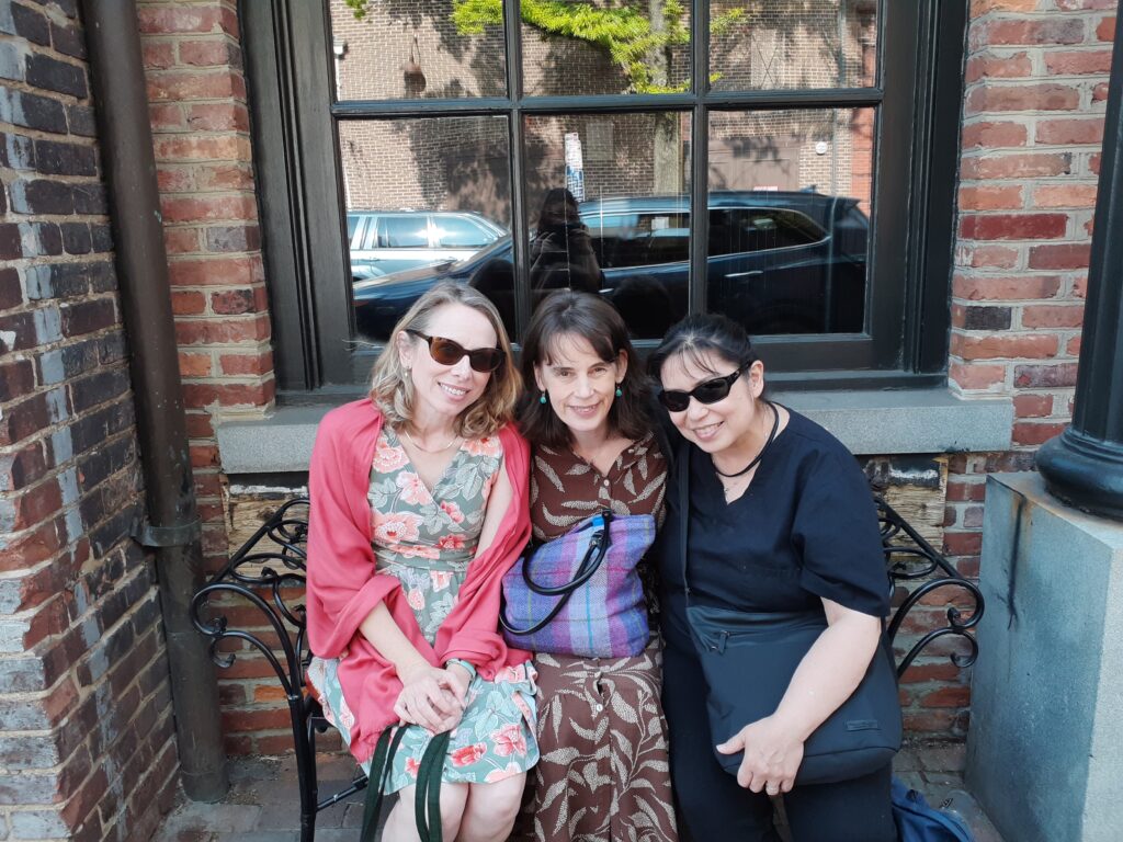 three ladies seated on a bench