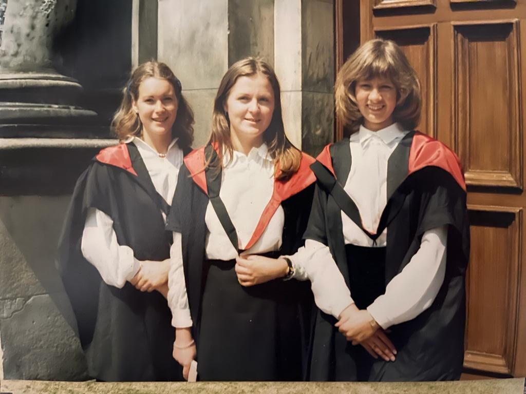Three female students in graduation robes