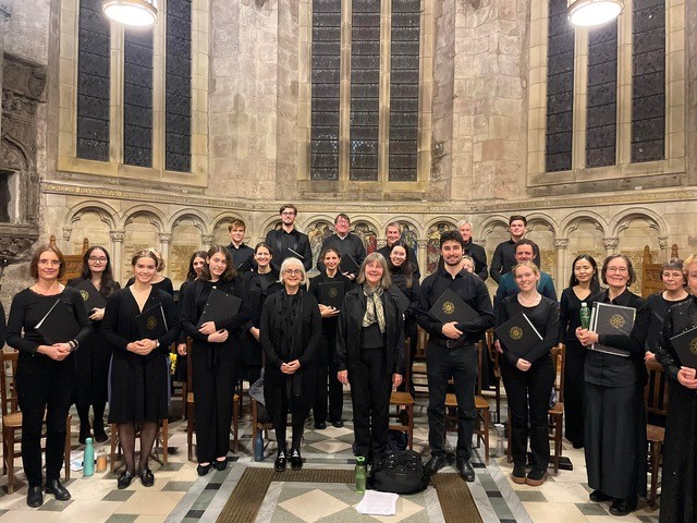 The Renaissance Singers pose for a group photo, all dressed in matching black outfits, in St Salvator's Chapel. 