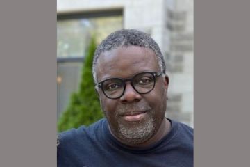 The image shows Pablo Herrera Veitia, a black man wearing glasses and a dark blue t-shirt.