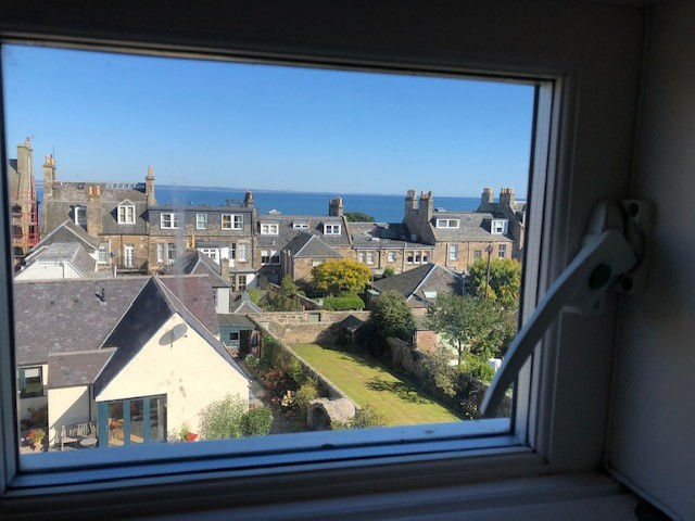 The image was taken in 2023 and is in colour. It shows rooftops in St Andrews, Scotland, taken from an upper floor window.
