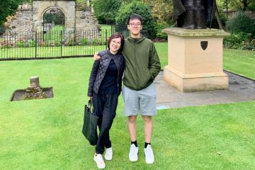 Helena and her son stand smiling in St Marys Quad, St Andrews. The Bishop Wardlaw statue can be seen to the right of the pair.