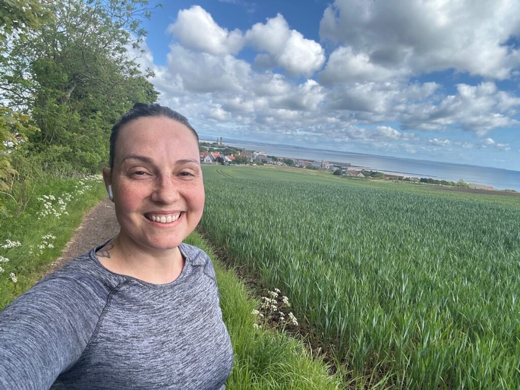 Clarissa Melo Czeskter poses for a selfie on a run on Grange Road, greenery can be seen in the background