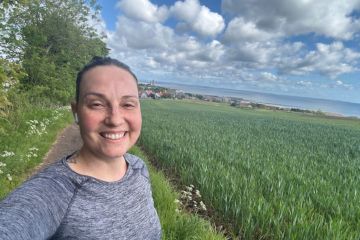 Clarissa Melo Czeskter poses for a selfie on a run on Grange Road, greenery can be seen in the background