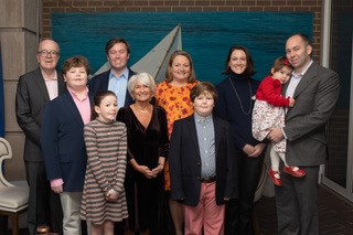 A family photograph featuring three generations of the Wood family at a formal celebration.