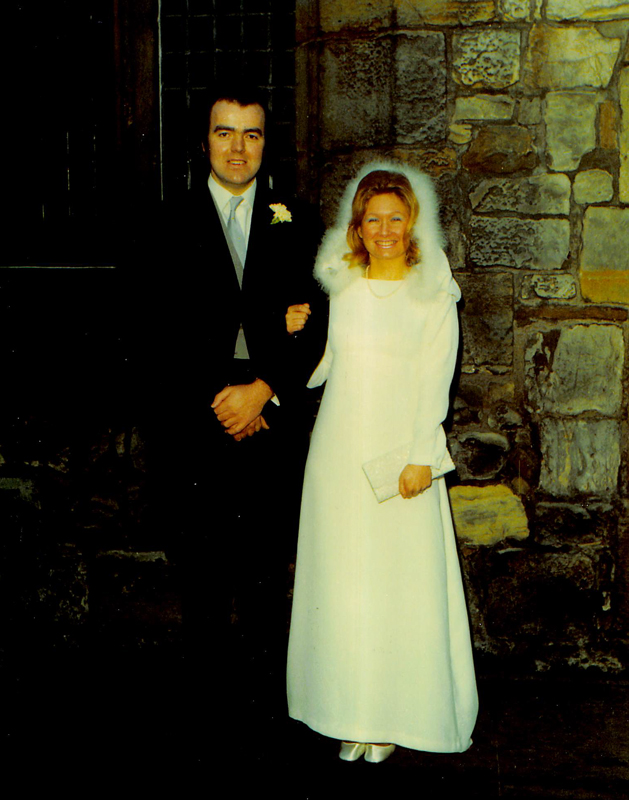 A wedding photo dating from 1972 which shows the happy couple, Alastair and Margaret Wood in front of a stone wall and chapel door.