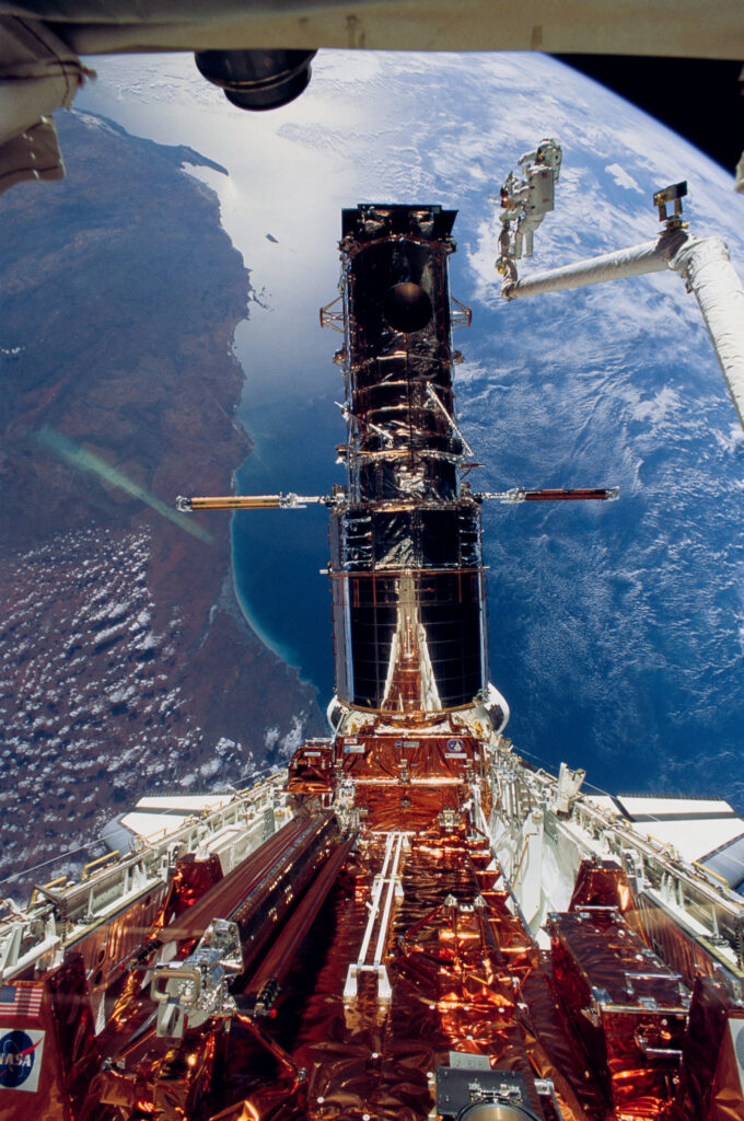 The first Hubble Space Telescope Servicing Mission (SM1). Orbiting Earth, astronauts F. Story Musgrave and Jeffrey A. Hoffman wrap up the last extravehicular activity 