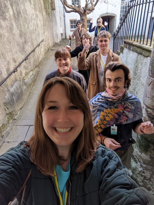 A selfie showing a group of students, fronted by Molly Ryan behind the camera. They are smiling and walking.