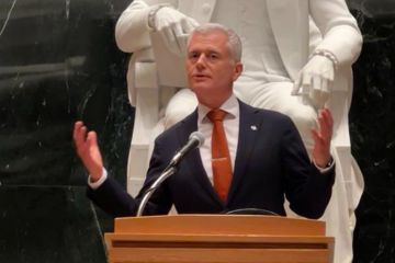 Mark Clampin, delivering a speech at a podium. His arms are raised in expression as he speaks