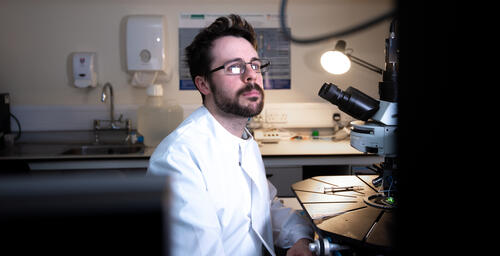A male researcher beside scientific equipment in a laboratory