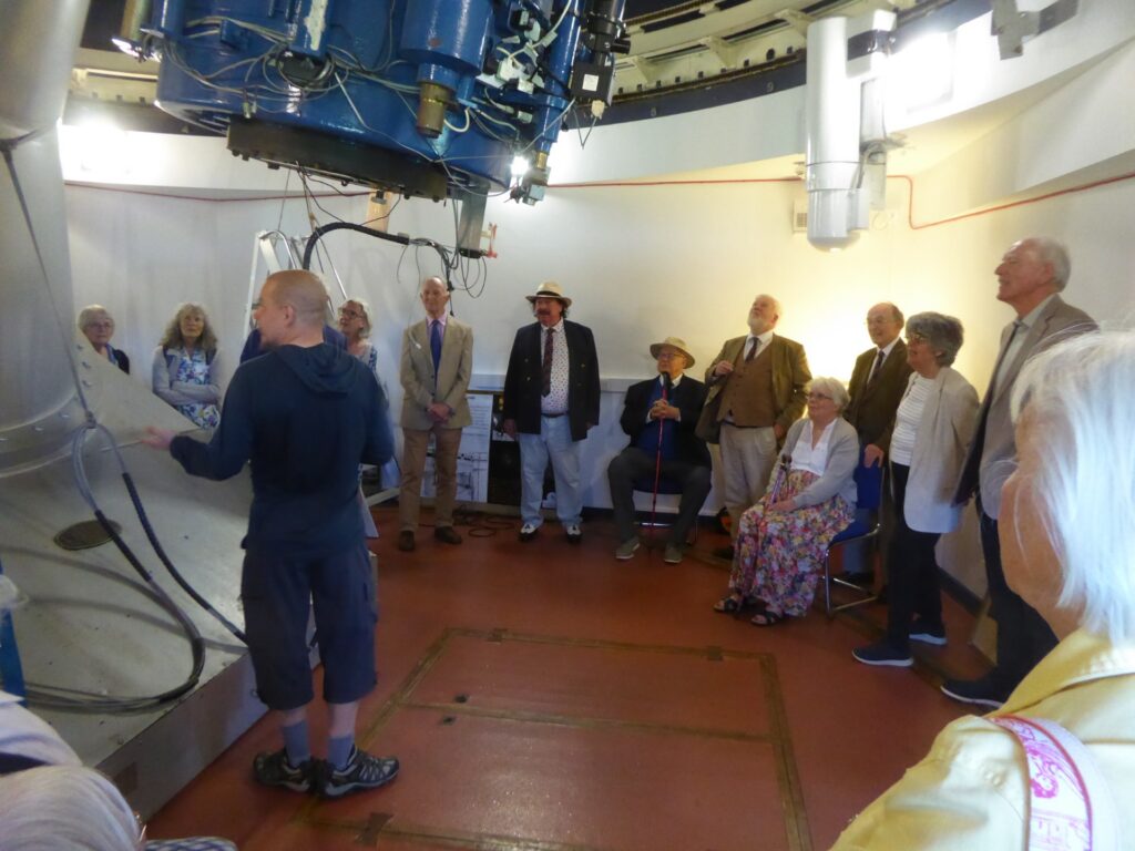 The Club is pictured on a tour of the University Observatory. The group stand around the edges of the room listening to the tour guide