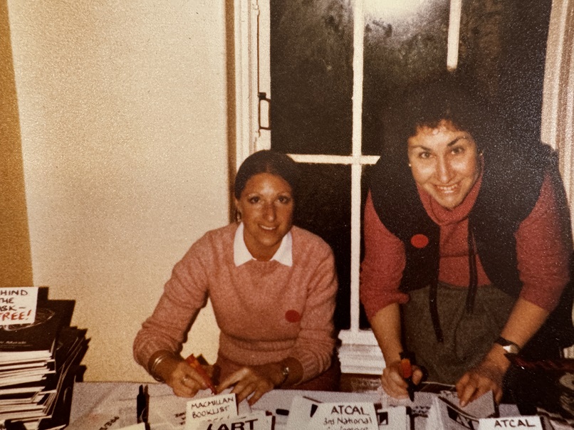 Two young women pictured in 1981 at the welcome desk of an ATCAL Conference event, writing badges