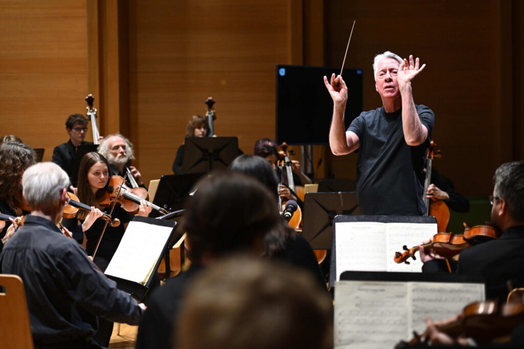 Alan Silvestri pictured conducting an orchestra. 