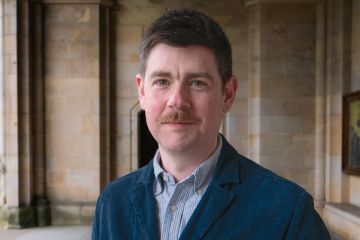 Headshot of Dr Niall Sreenan in the cloisters, St Salvator's Quad