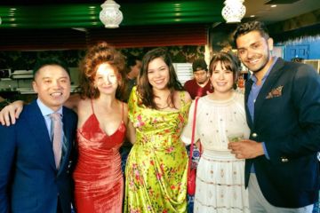 Five friends pose smiling for a group photo dressed in formalwear