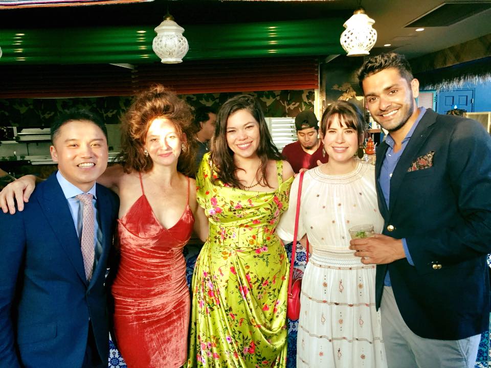 Five friends pose smiling for a group photo dressed in formalwear