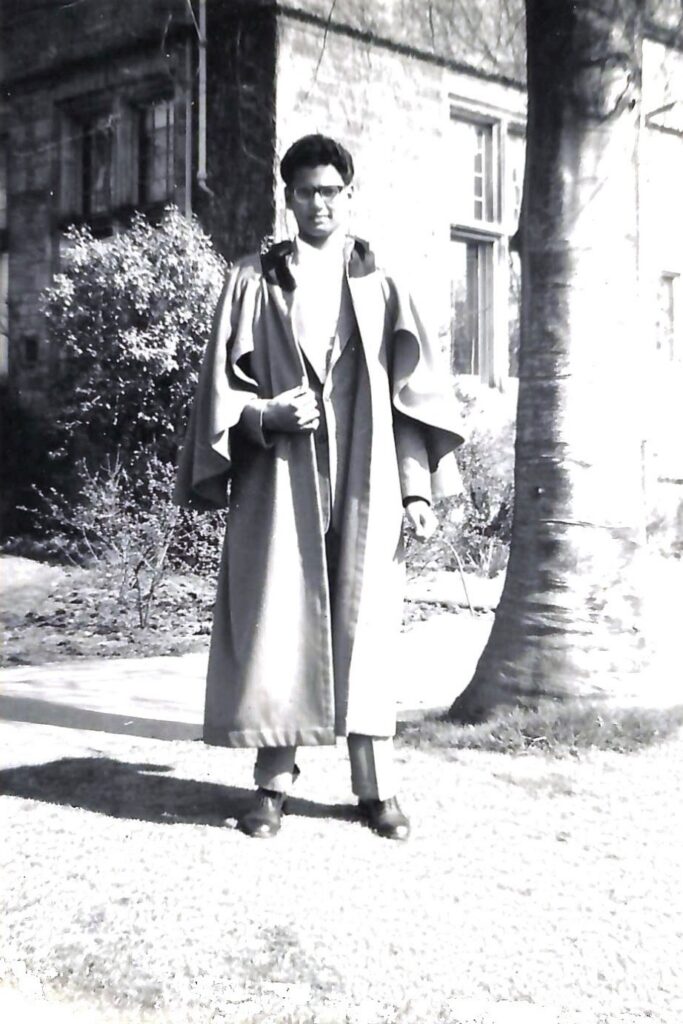 A 1960s black and white portrait of a young man from Trinidad and Tobago. He is pictured wearing the student gown of the University of St Andrews.