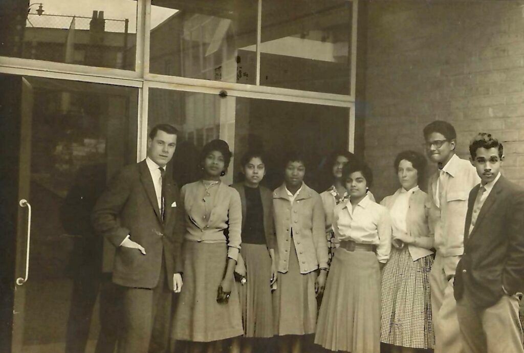 A black and white photograph from the early 1960s showing nine University of St Andrews students standing outside the Student Union entrance.