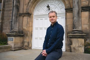 Professor Lars Kotthoff poses for a photo outside Lower & Upper College Halls 